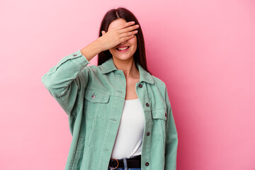 Young caucasian woman isolated on pink background covers eyes with hands, smiles broadly waiting for a surprise.