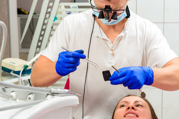 After filling, the dentist removes the excess material from the tooth with a copying tracing paper.