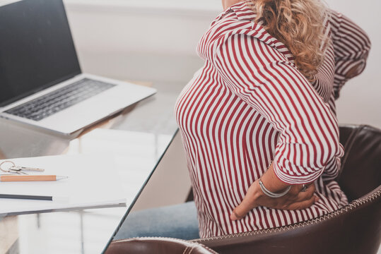 Close Up Rear View Stressed Young Woman Touching Lower Back Feeling Discomfort, Suffering From Sudden Pain Due To Sedentary Lifestyle Or Long Computer Overwork In Incorrect Posture At Home Office..