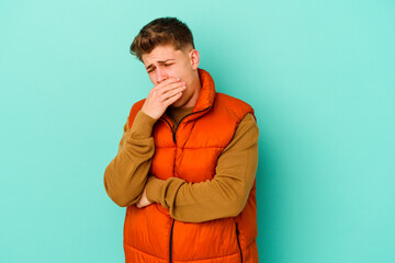 Young caucasian man isolated on blue background suffers pain in throat due a virus or infection.