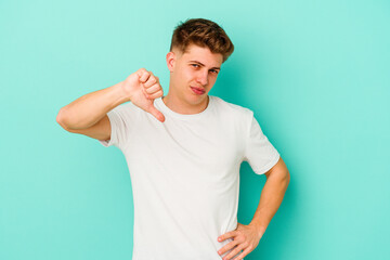 Young caucasian man isolated on blue background showing thumb down, disappointment concept.