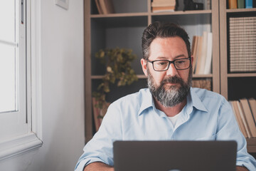 Happy young caucasian businessman smiling working online watching webinar podcast on laptop and...