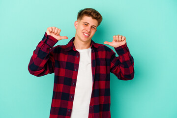 Young caucasian man isolated on blue background feels proud and self confident, example to follow.