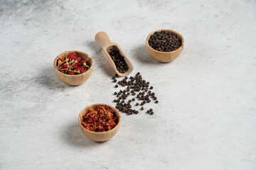 Fototapeta premium Three bowls of pepper spices on marble background