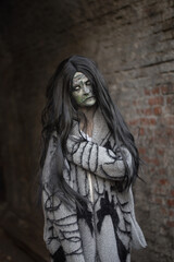 Ein Zombi Mädchen kommt aus der Dunkelheit raus. Sie lebt in der alter Gebäude. Sie ist sehr hässlich und gruselig. Passt zu einem Horror Film oder Buch.Das Mädchen hat lange, schwarze Haare.