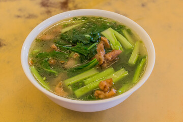 Soup in Sabah, Malysia, with fried meat and greens
