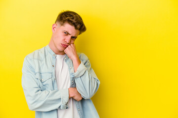 Fototapeta premium Young caucasian man isolated on yellow background who feels sad and pensive, looking at copy space.