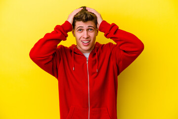Young caucasian man isolated on yellow background screaming, very excited, passionate, satisfied...