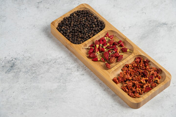 Green tagliatelle, dry spices and olive oil on marble background