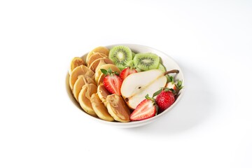 Bowl with pancakes, strawberries, pear, kiwi and peanut butter