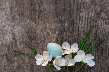 Easter blue egg with white cherry flowers on a wooden background. Easter still life.