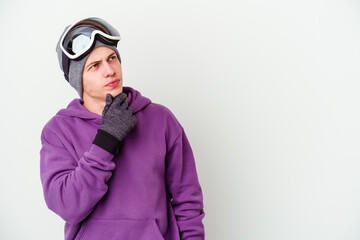 Young man holding a snowboard board isolated on white background looking sideways with doubtful and skeptical expression.