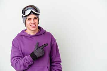 Young man holding a snowboard board isolated on white background smiling and pointing aside, showing something at blank space.