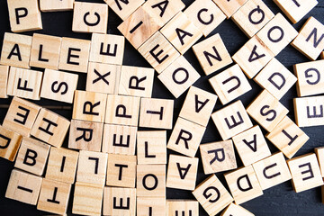alphabet blocks with letters on a black background are chaotically scattered