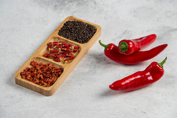 Hot chili peppers and spices on marble background