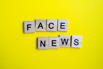 top view of alphabet blocks with letters on bright yellow background. news face - lettering