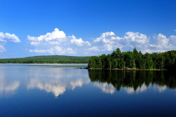 Puffy Cumulus clouds on a large calm Northern Maine Lake