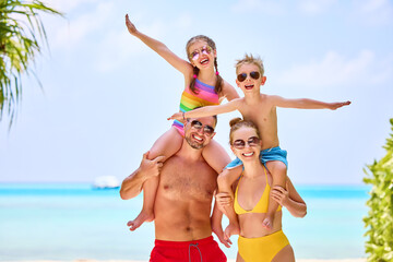 Happy family in colorful swimsuits on beach