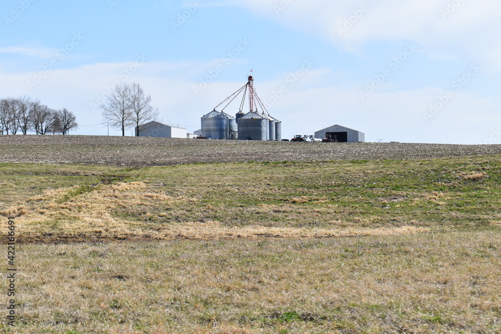 Sticker grain bins and barns in a field