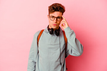 Obraz premium Young student man isolated on pink background pointing temple with finger, thinking, focused on a task.