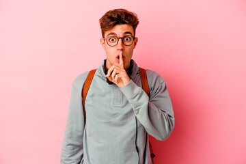 Young student man isolated on pink background keeping a secret or asking for silence.