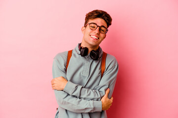 Young student man isolated on pink background laughing and having fun.