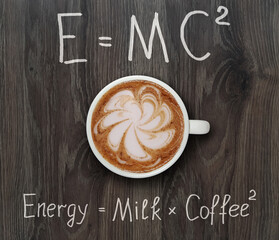 A cup of coffee is on a gray wooden board with funny formulas.