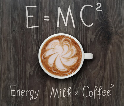A cup of coffee is on a gray wooden board with funny formulas.