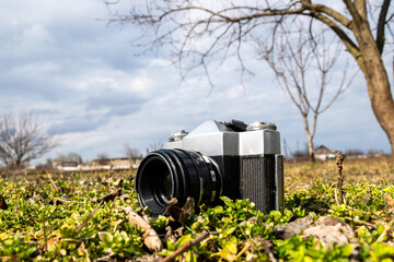 forgotten old film camera lies in the garden