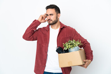 Young caucasian man making a move while picking up a box full of things isolated on white...