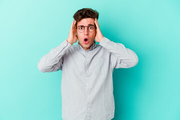 Fototapeta premium Young caucasian man isolated on blue background being shocked, she has remembered important meeting.