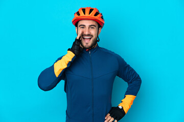 Fototapeta premium Young cyclist man isolated on blue background shouting with mouth wide open
