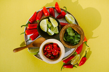overhead shot of spicy chiles, cilantro, and lime as garnishes or toppings