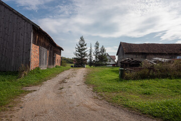 Fototapeta na wymiar Country road among farm buildings
