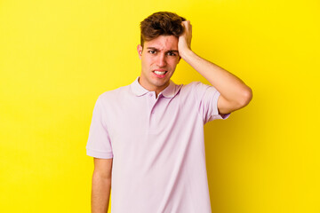 Young caucasian man isolated on yellow background forgetting something, slapping forehead with palm and closing eyes.