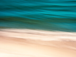 Fototapeta na wymiar Brilliant Turquoise Blue Waves and Gold Sand Motion Blur Panning Seascape