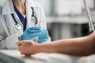 A nurse in the lab takes a blood test from a vein, a close-up plan without a face.