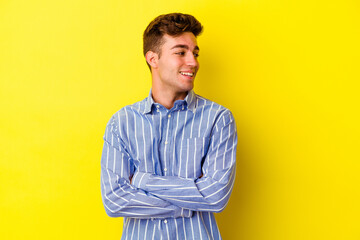 Young caucasian man isolated on yellow background laughing and having fun.