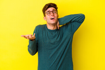 Young caucasian man isolated on yellow background screaming with rage.