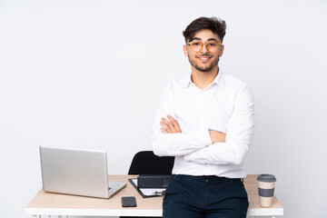 Arabian man in a office isolated on white background with arms crossed and looking forward