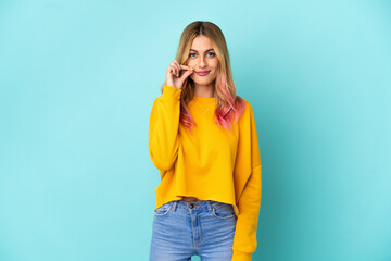 Young woman over isolated blue background showing a sign of silence gesture