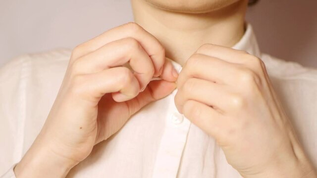Close up woman buttoning white shirt. Business woman prepare for work in office 