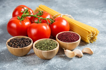 Variety of spices, vegetables and raw beans on blue background