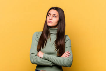 Young Indian woman isolated on yellow background dreaming of achieving goals and purposes
