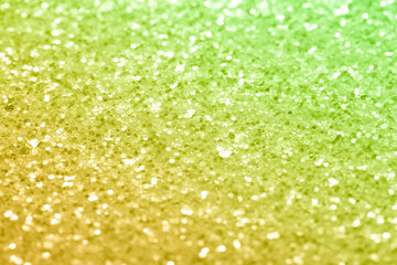 Sparkling abstract yellow background. Bright lemon yellow glitter with blur, close-up abstraction