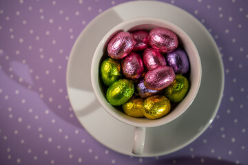 cup with chocolates purple background