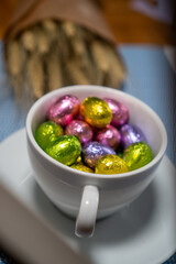 cup with chocolates and dried flowers on a blue background