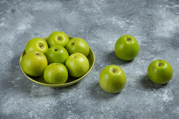 Bunch of green apples in green bowl