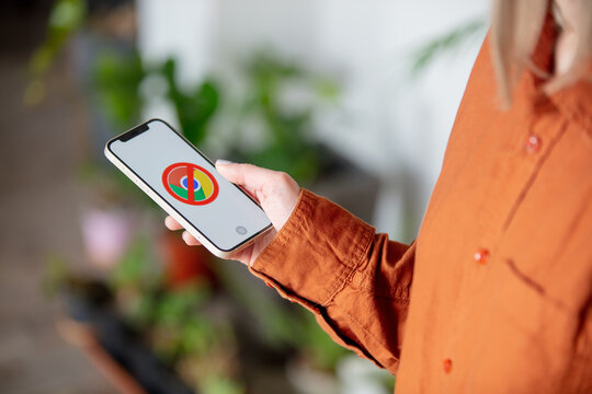Wroclaw, Poland - 20 March 2021: woman holding iPhone 12 with the blocked Google Chrome logo on the screen at home