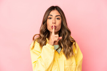 Young caucasian woman isolated keeping a secret or asking for silence.